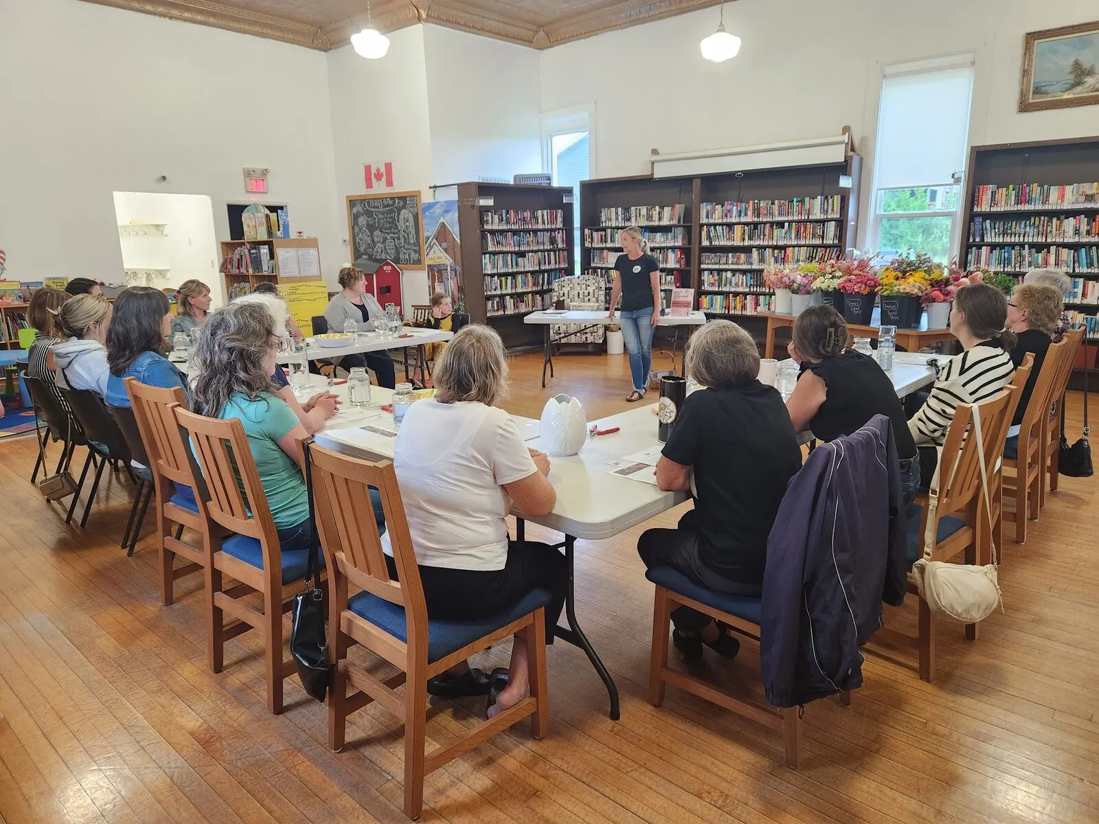 Adults gathered in a circle at a community meeting in the library